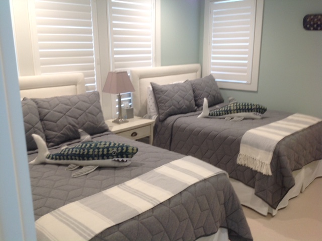 two beds in a room with white and gray bedding