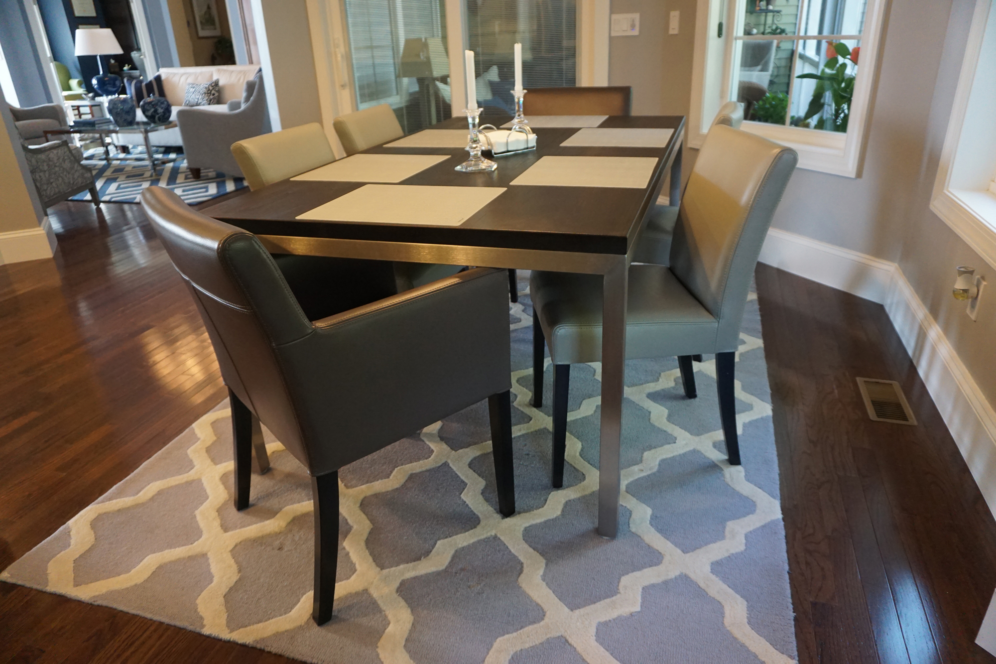 a dining room table with chairs and a rug