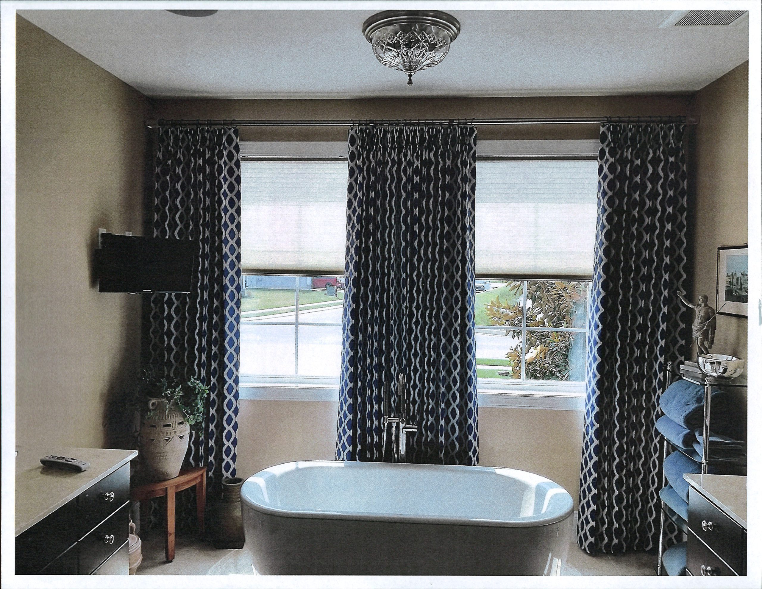 a bathroom with a bathtub and window curtains