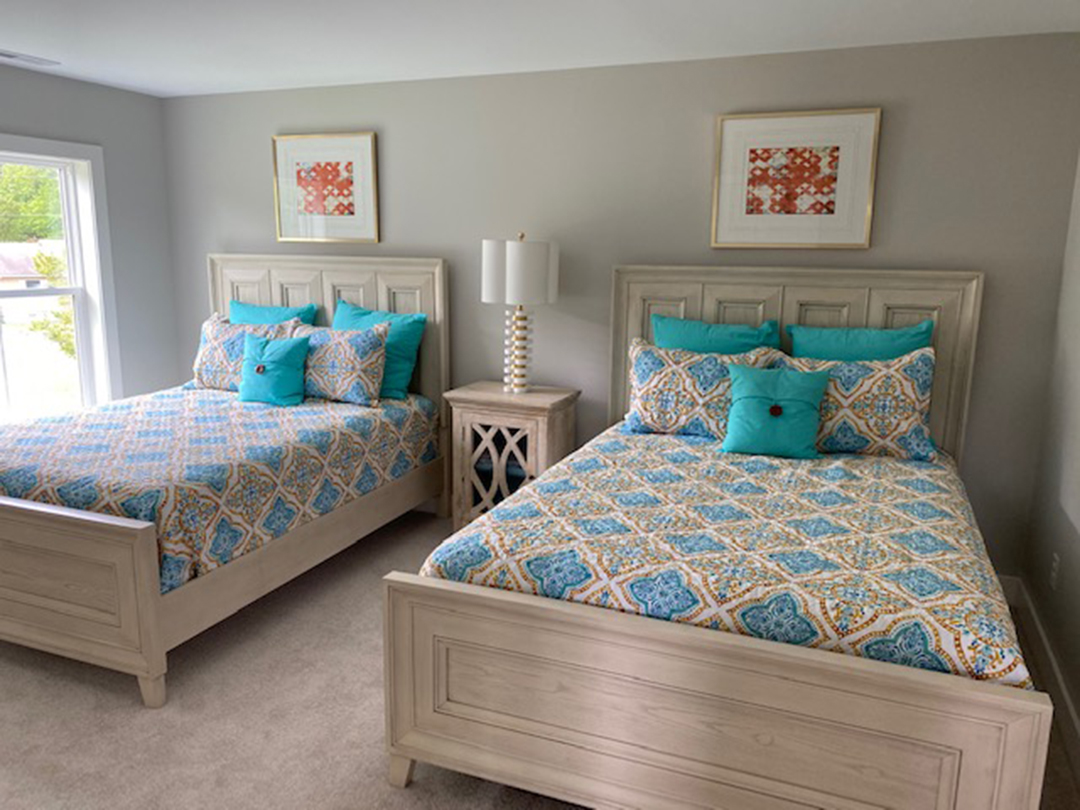 two beds in a bedroom with blue and yellow comforters