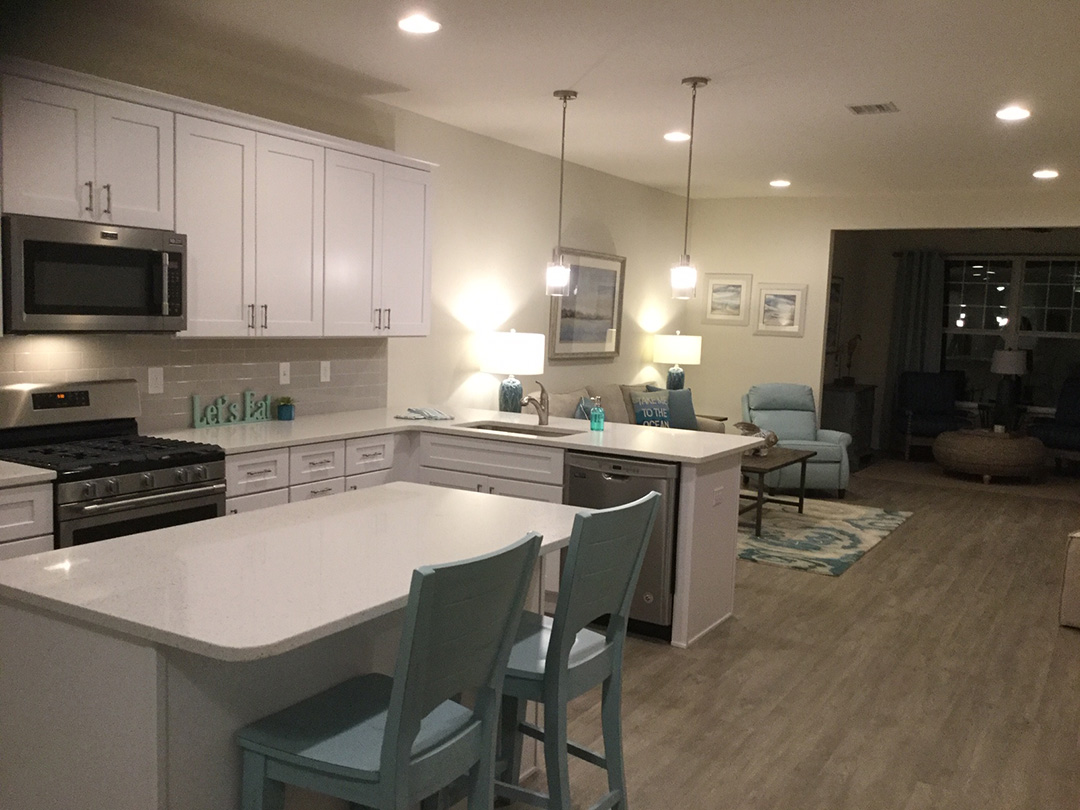 a kitchen with white cabinets and blue chairs