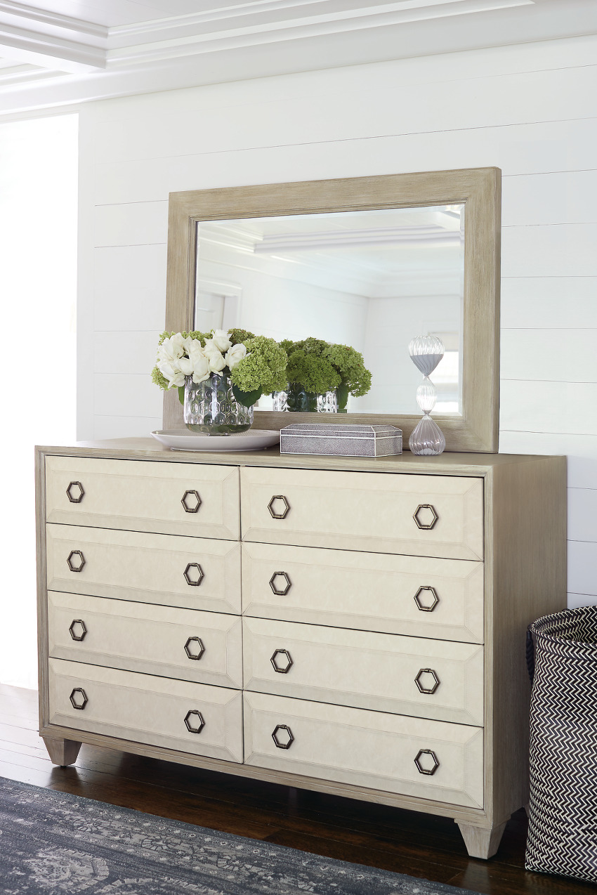a dresser with a mirror and vases on top
