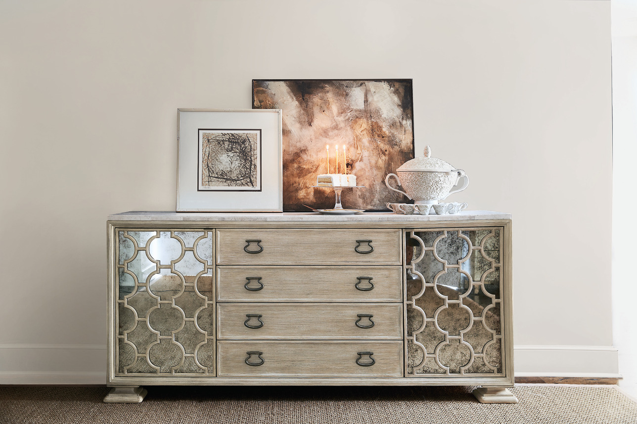 a dresser with a candle and pictures on it