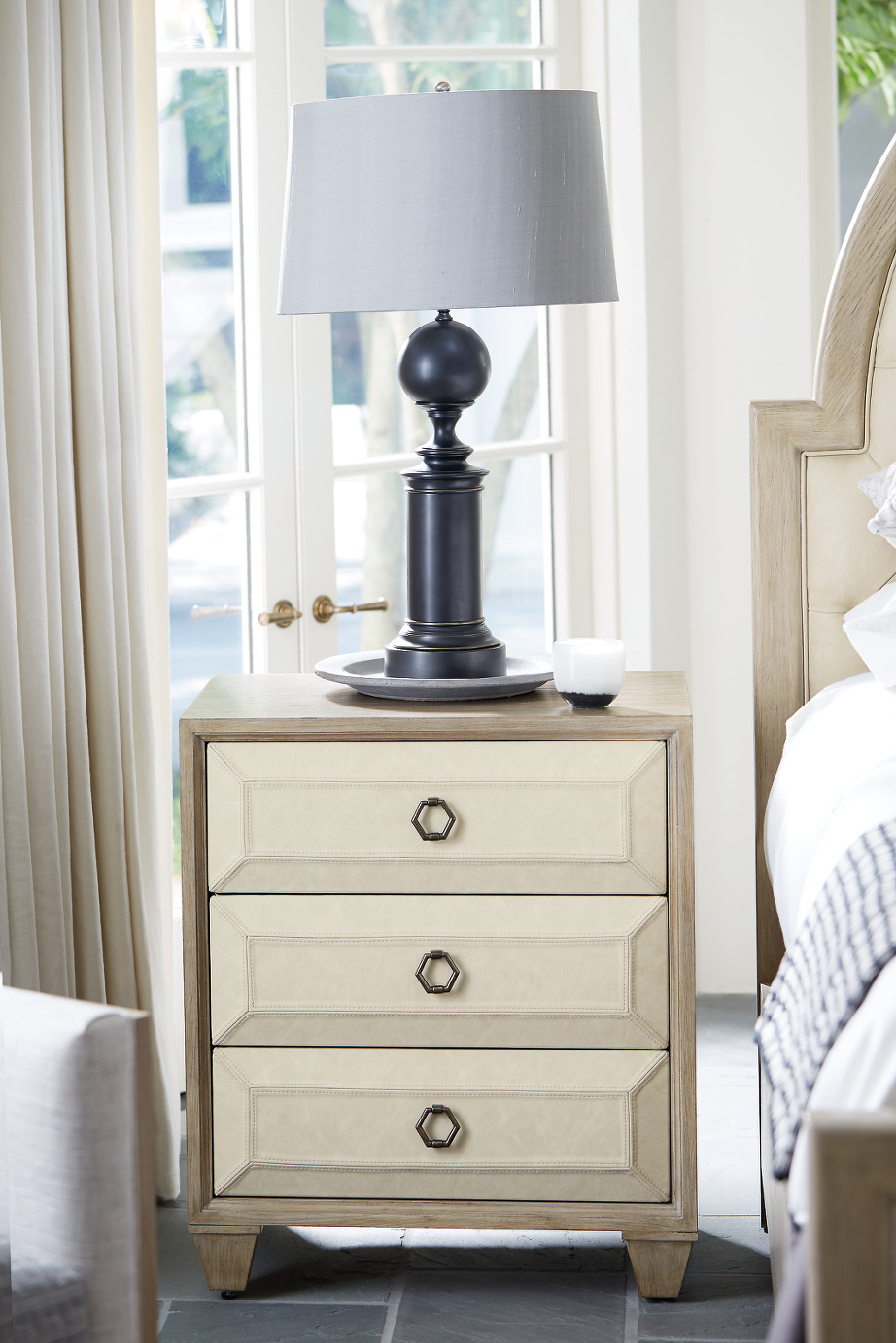 a white nightstand with a lamp on top of it