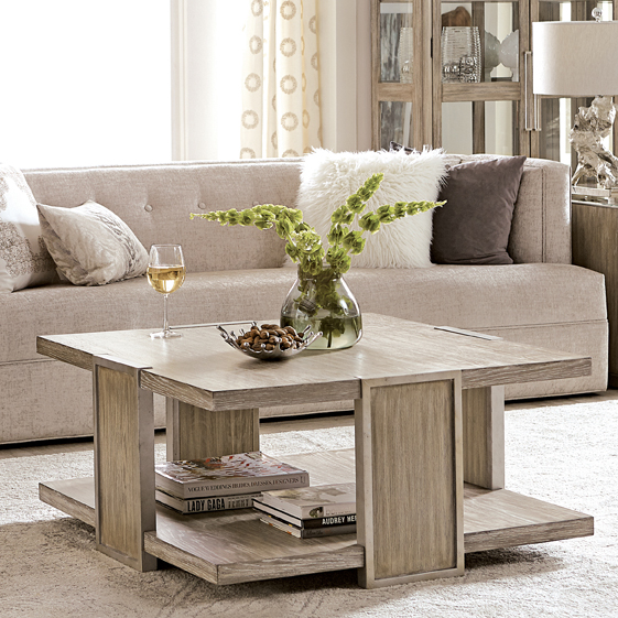 a living room with a couch, coffee table and vase