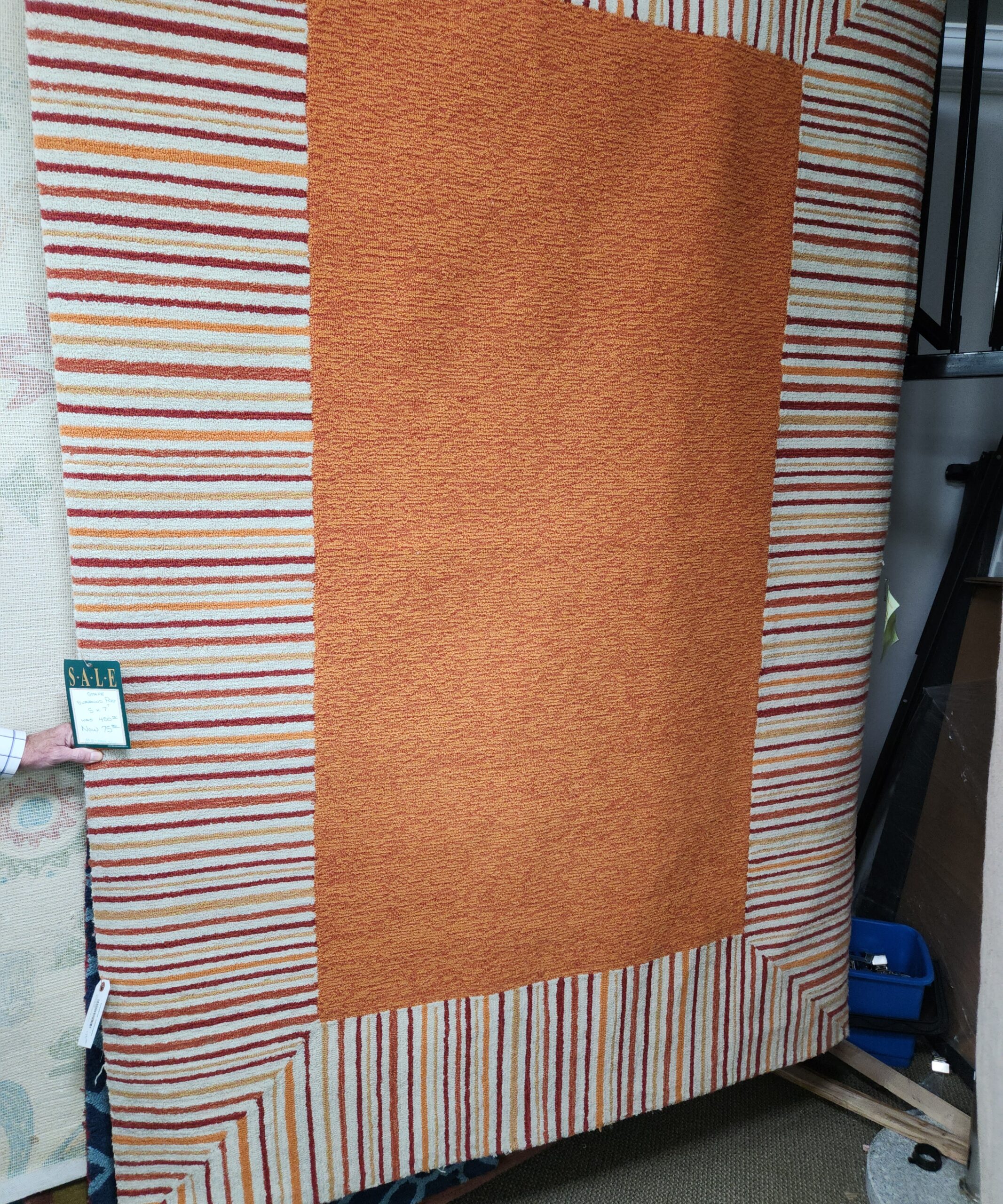 an orange and white striped blanket on top of a bed
