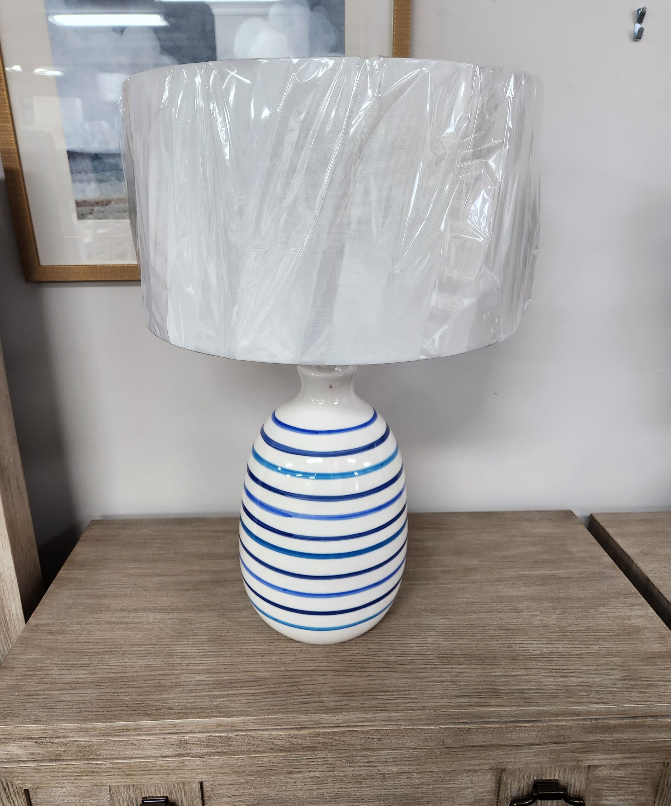a white and blue striped vase hanging on a wall