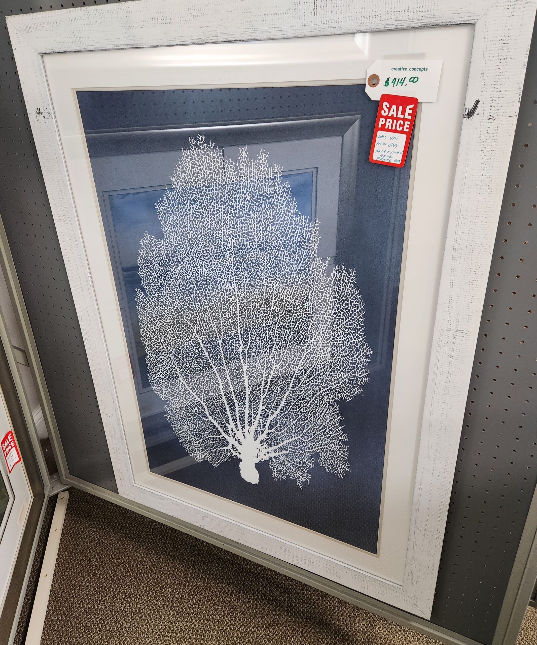 a white framed art piece on display in a store
