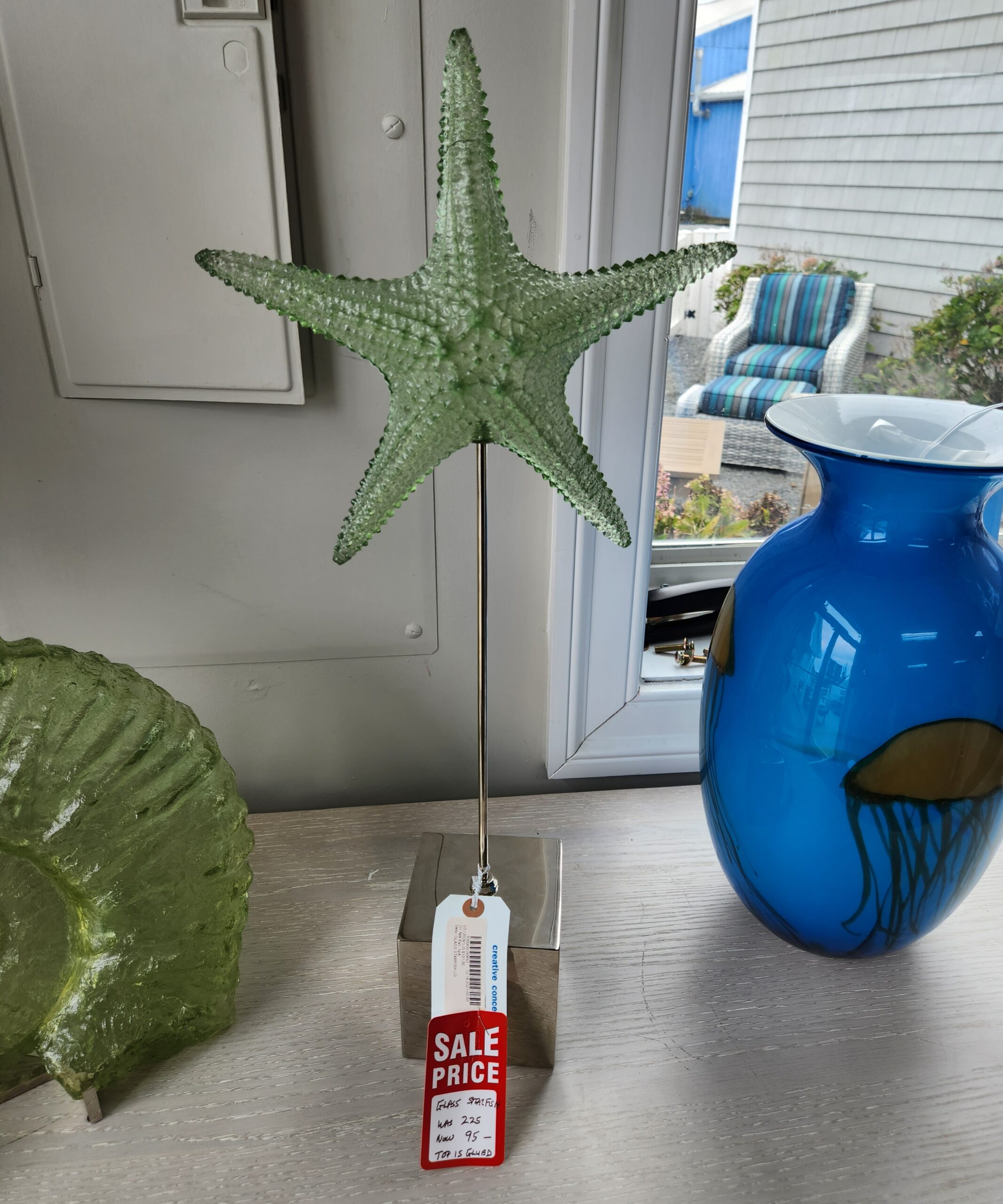 a green starfish hanging from a hook on a wall
