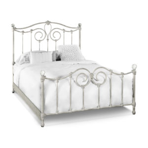 a white bed with a metal frame and headboard