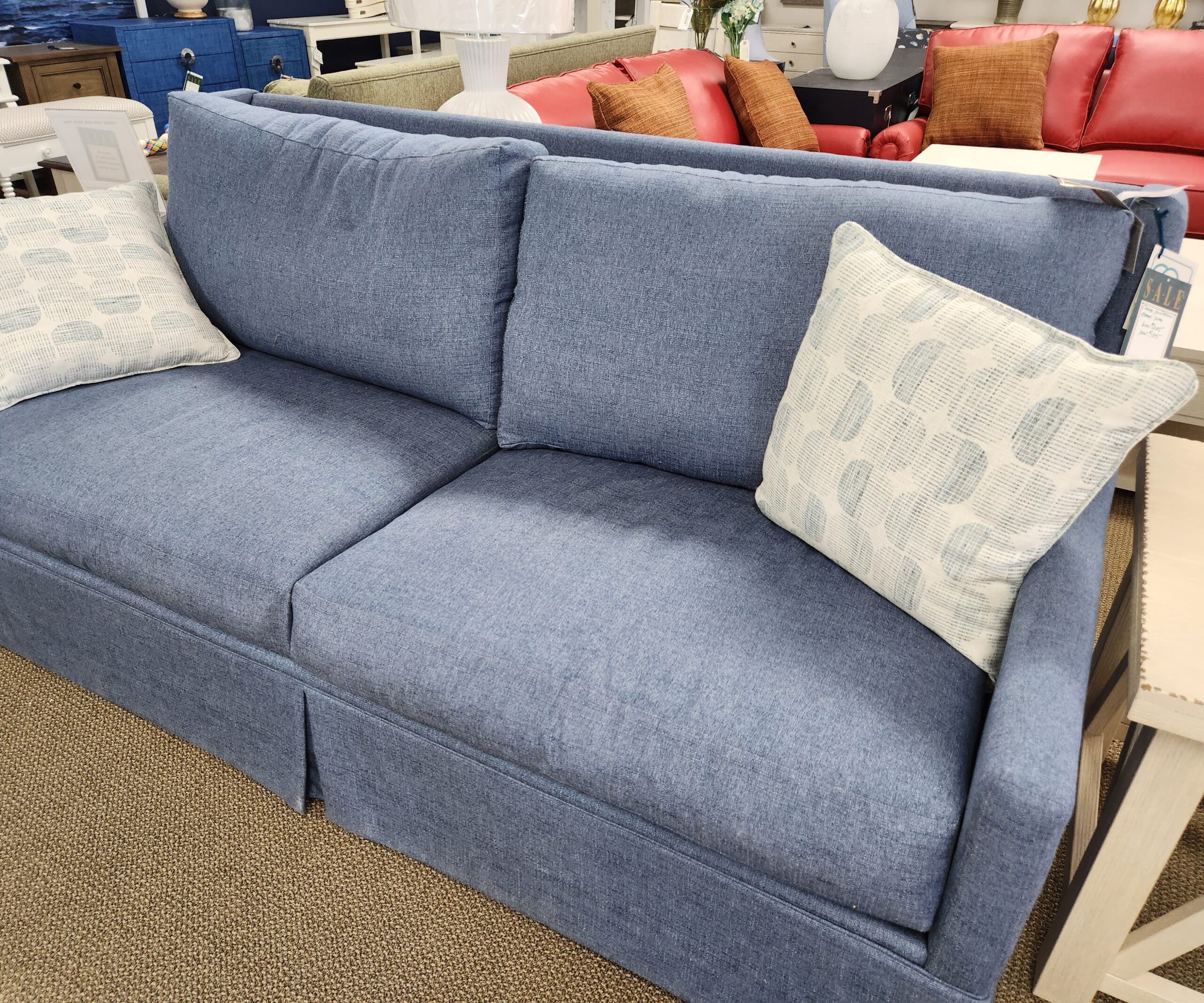 a blue couch with pillows on it in a store