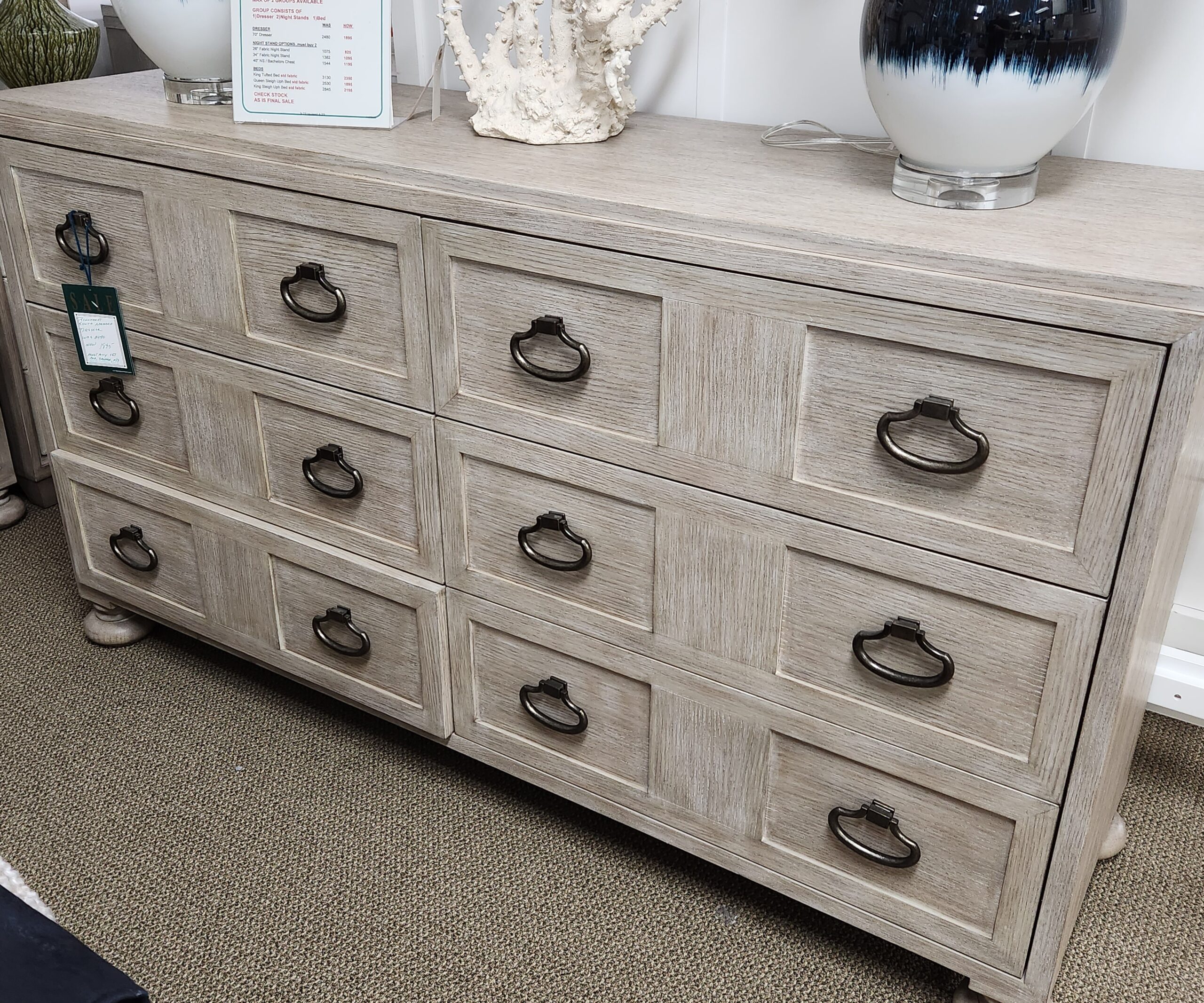 a white dresser with many drawers and knobs
