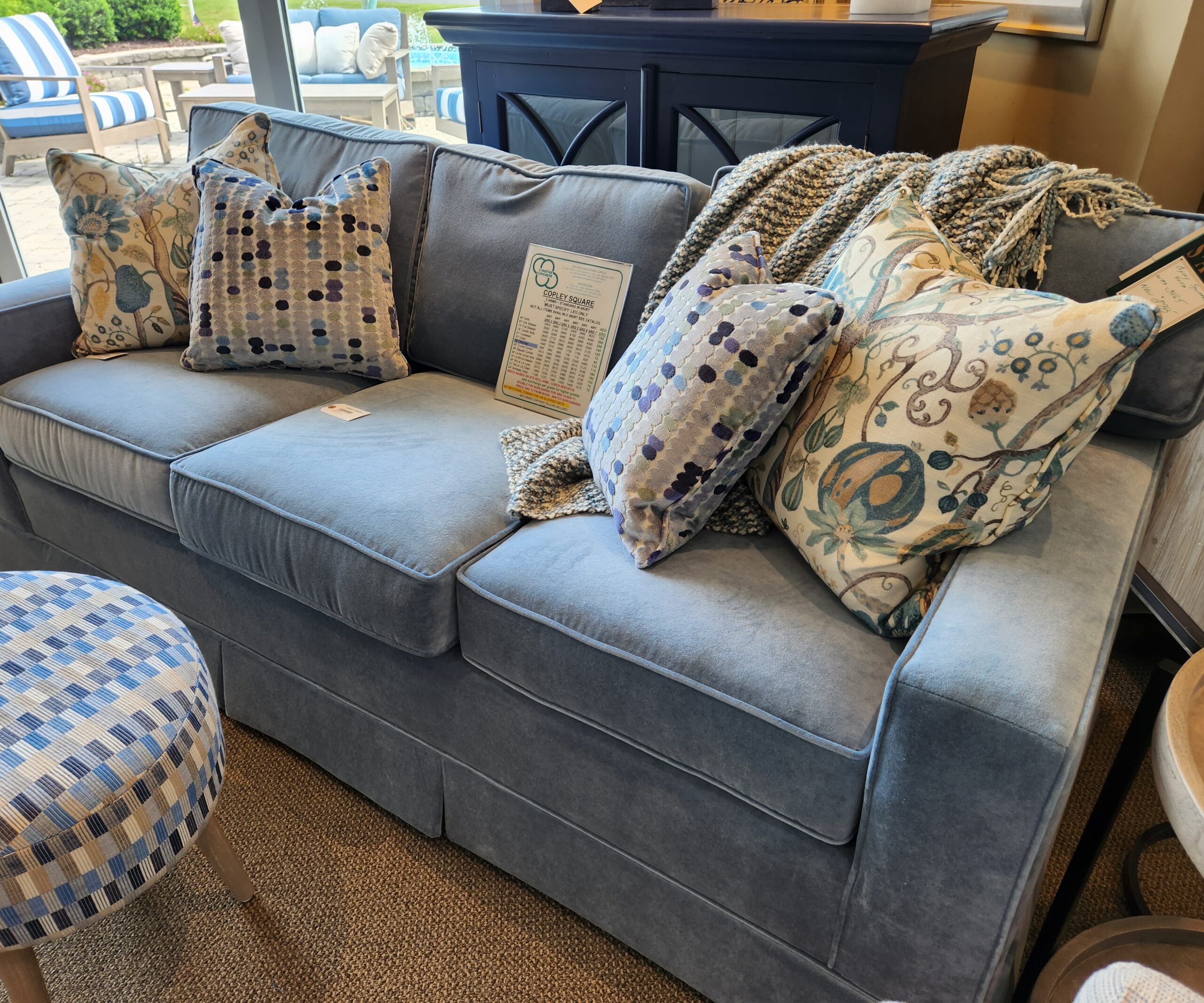 a blue couch with many pillows on it