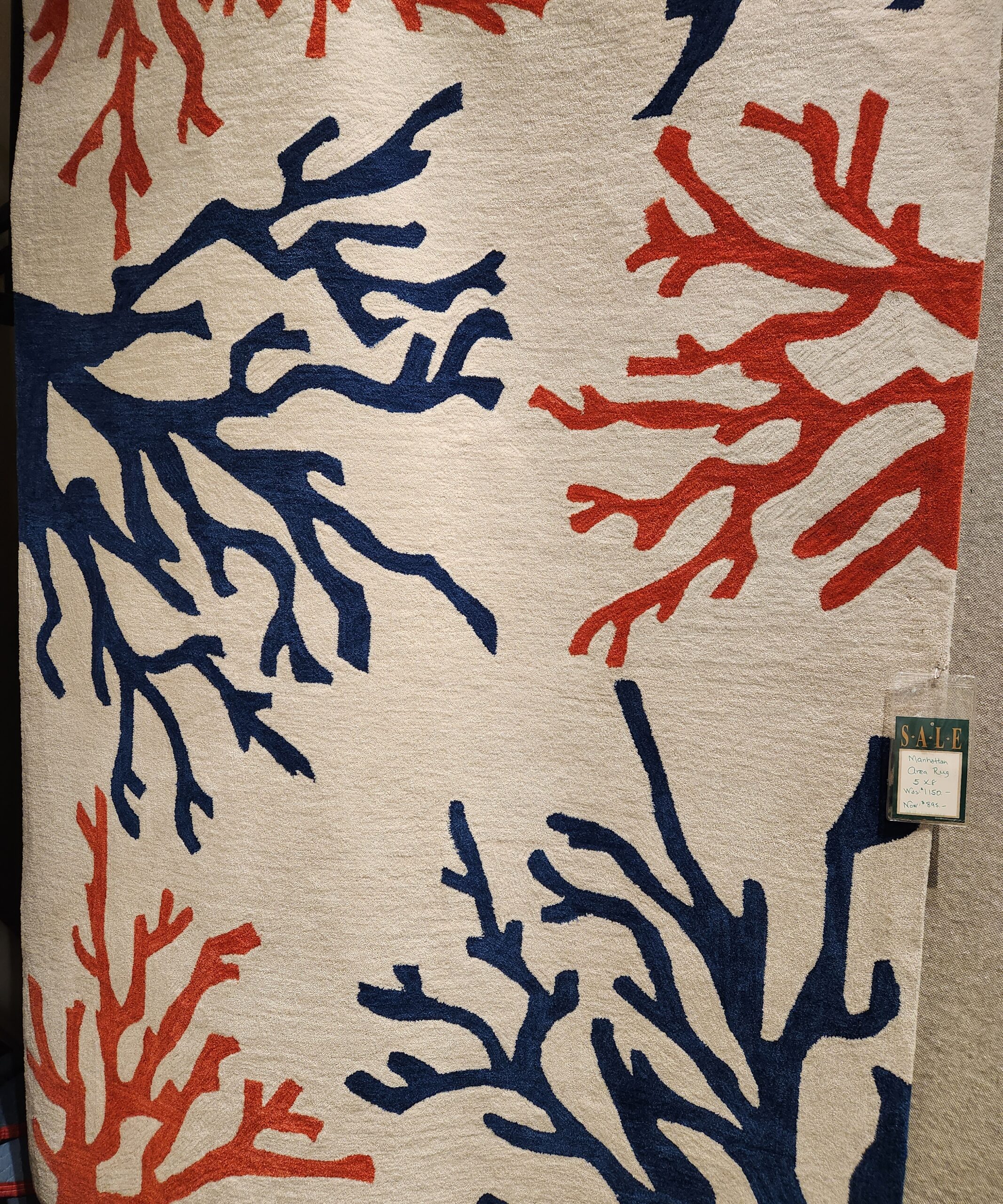 a red, white and blue rug with corals on it