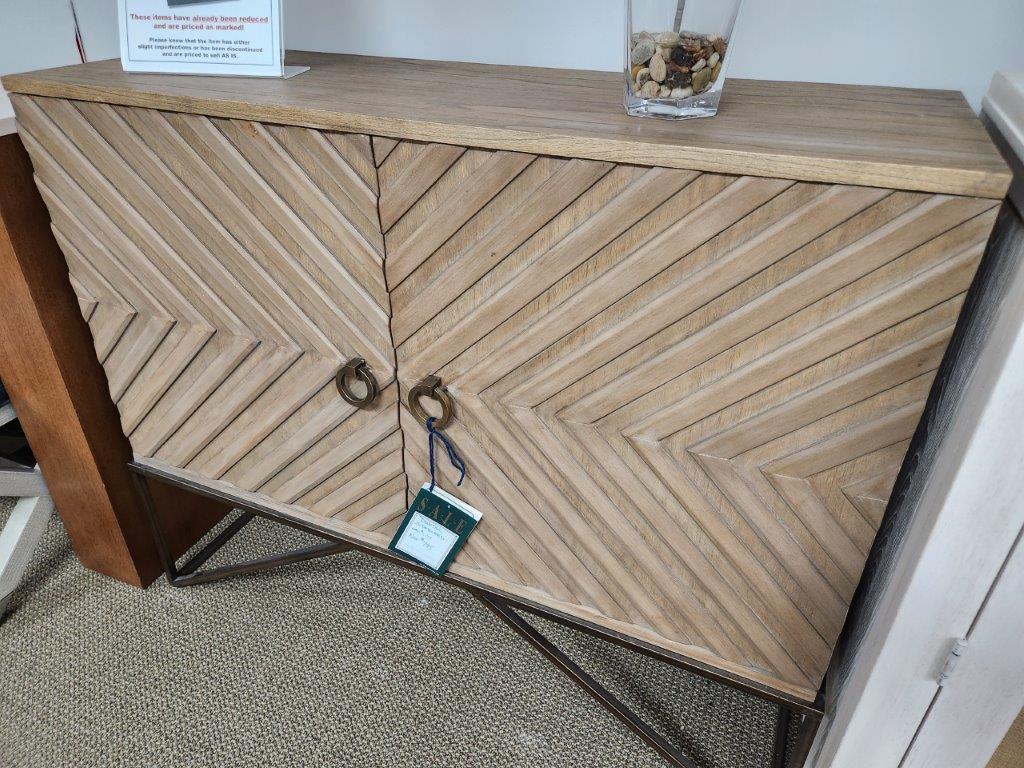 a wooden cabinet with two keys and a glass on top