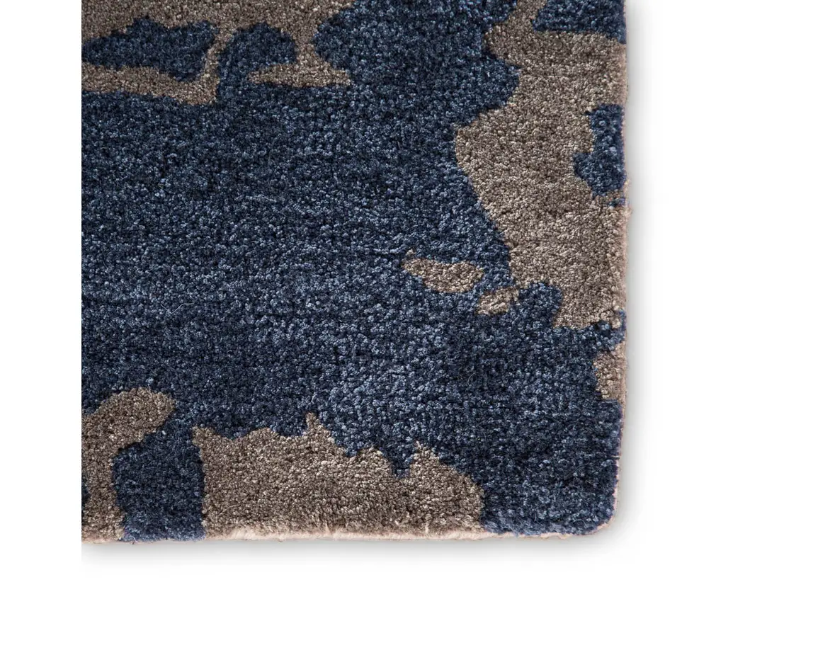 a blue rug with grey and brown designs on it