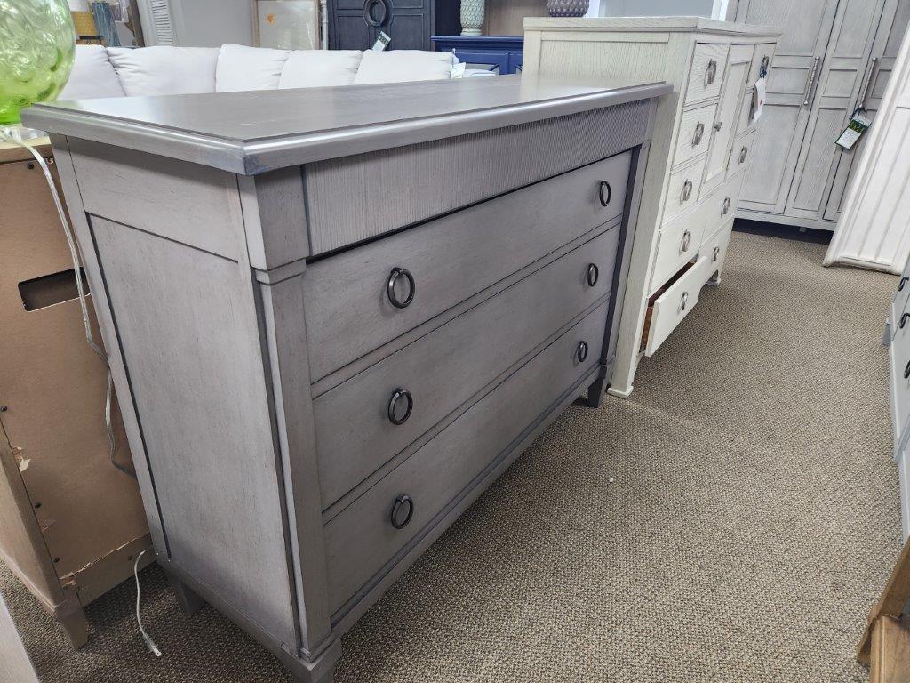 a gray dresser in a store next to other furniture