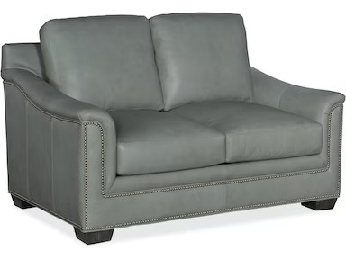 a gray leather couch with nail polishing on it
