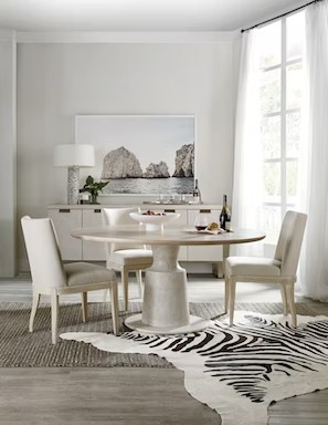 a white dining room with zebra rug and chairs
