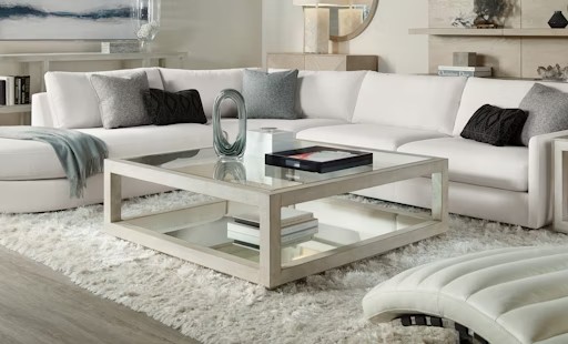 a living room filled with furniture and a white rug