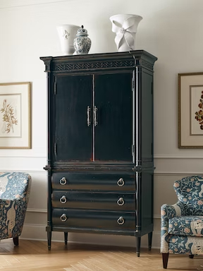 a black armoire with two vases on top of it
