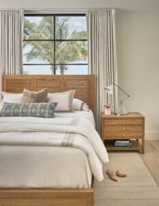 a bedroom with a bed, dresser and window