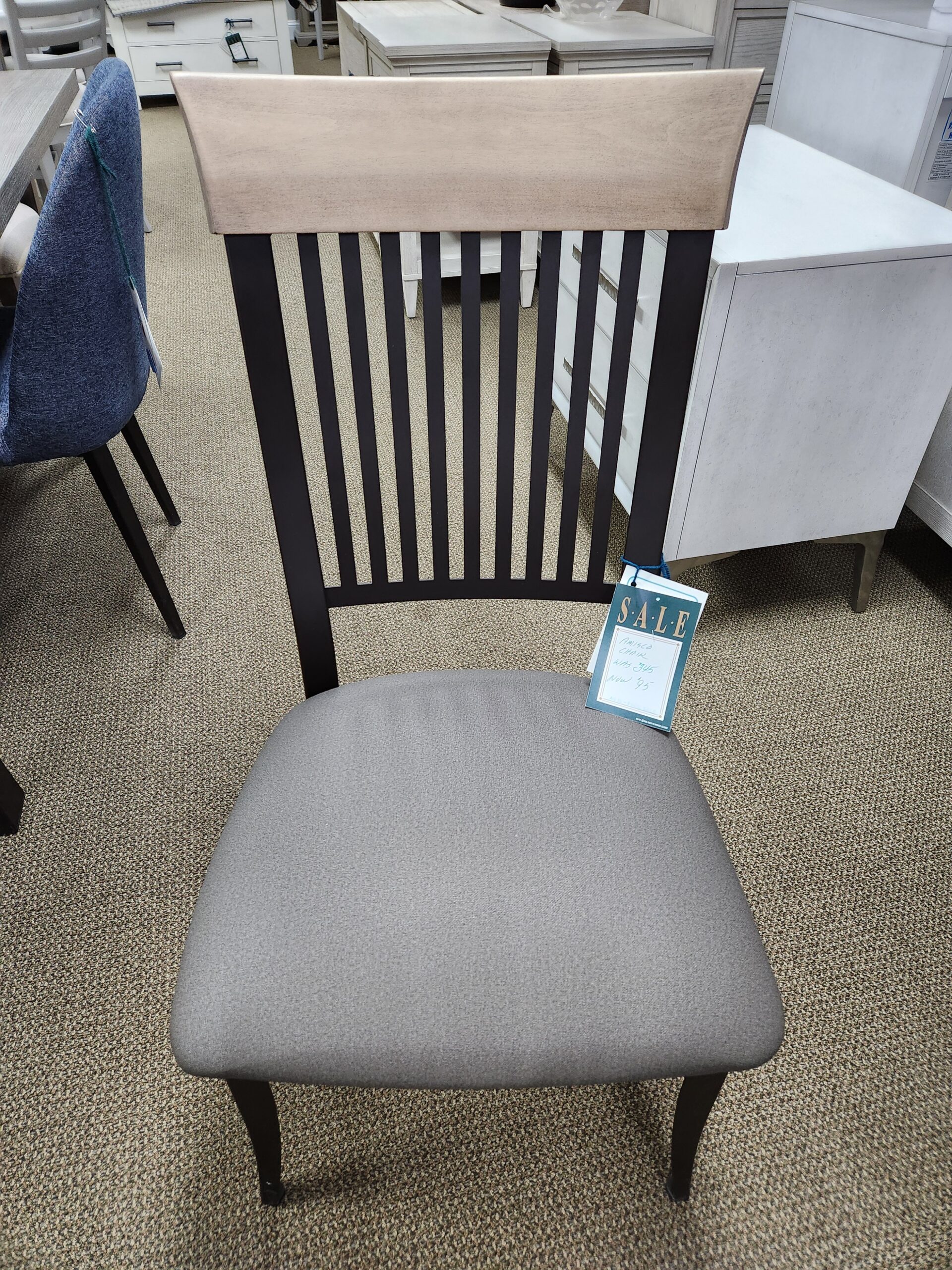 a chair with a cushion on it next to a desk