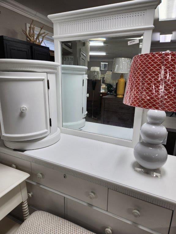 a white dresser with a red lamp on it
