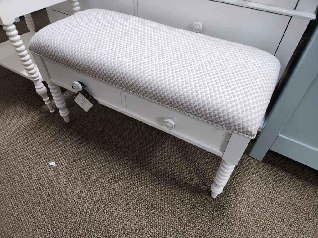 a white bench sitting in front of a dresser