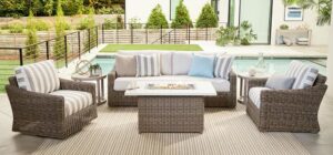 a patio with wicker furniture and a pool in the background