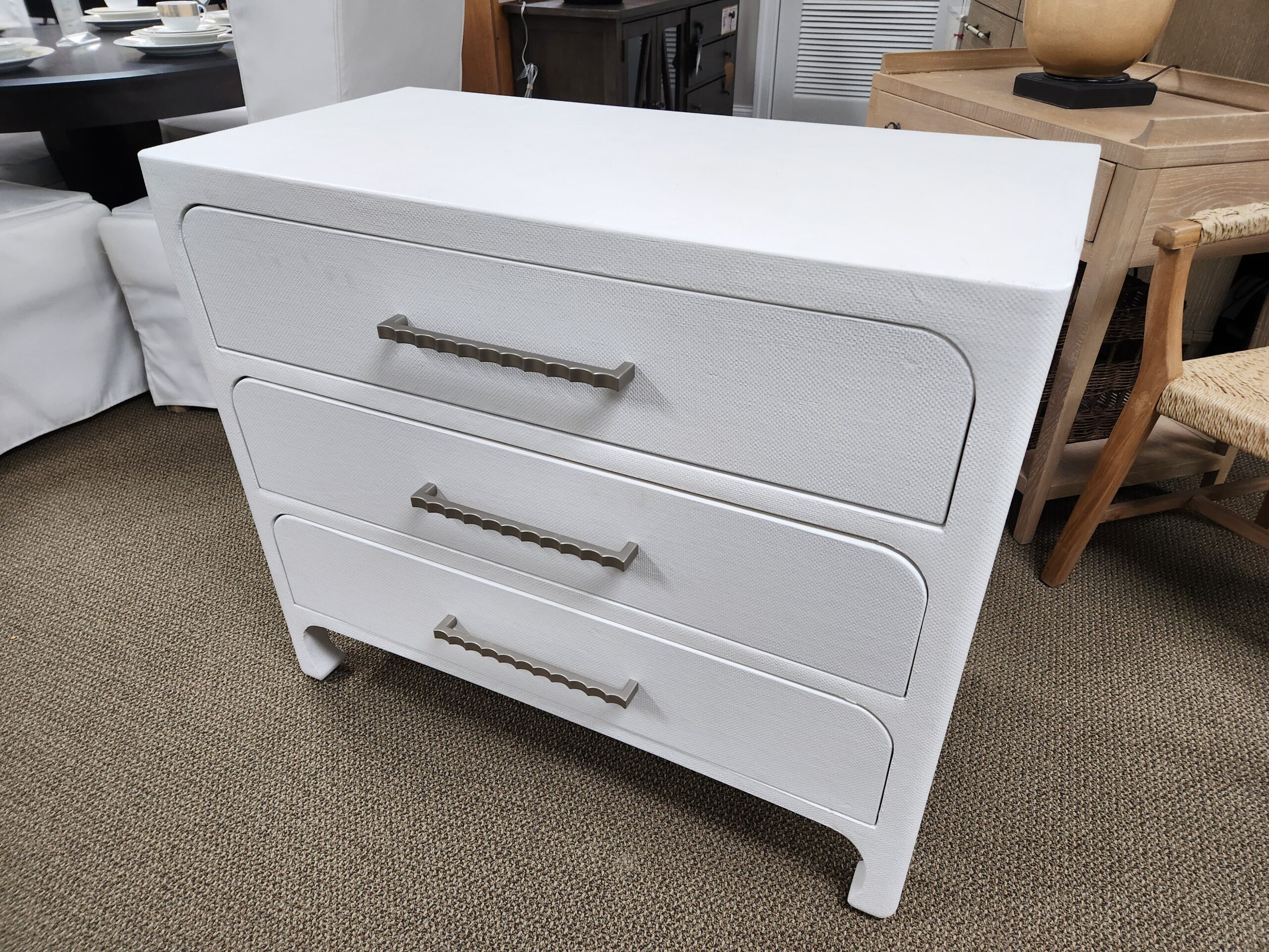 a white chest of drawers sitting on top of a carpeted floor