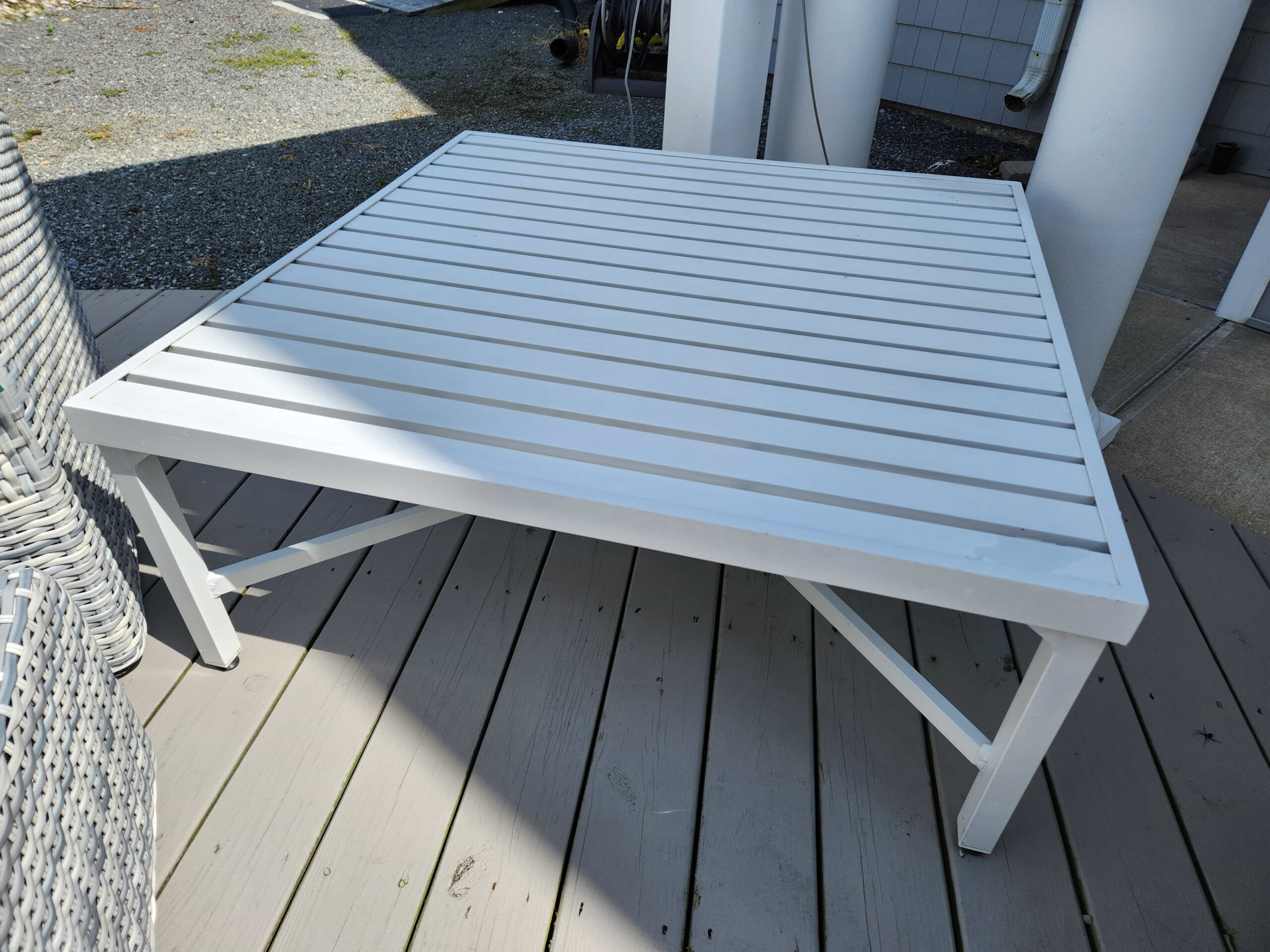 a white table sitting on top of a wooden deck