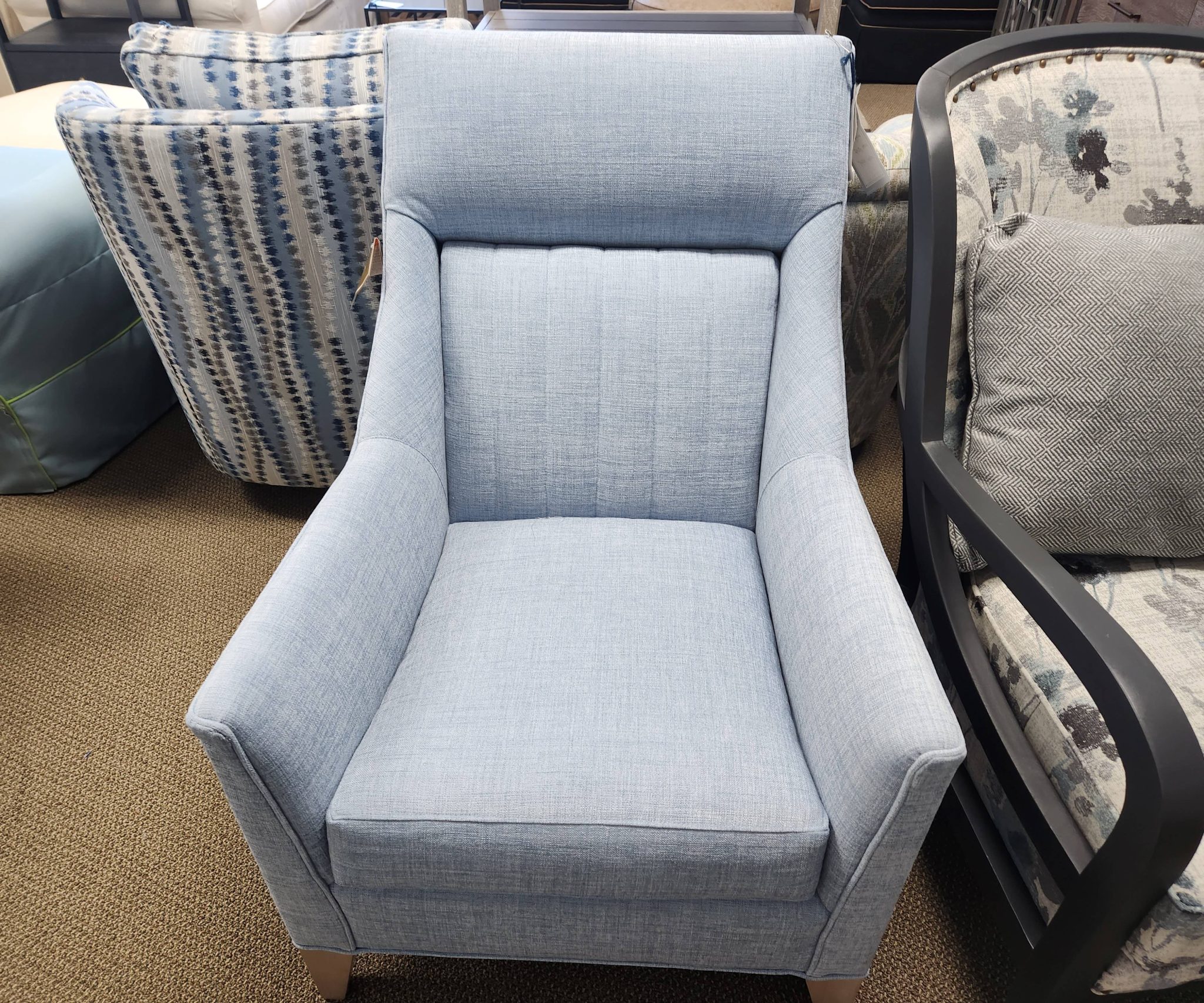 a blue chair sitting next to a pile of pillows