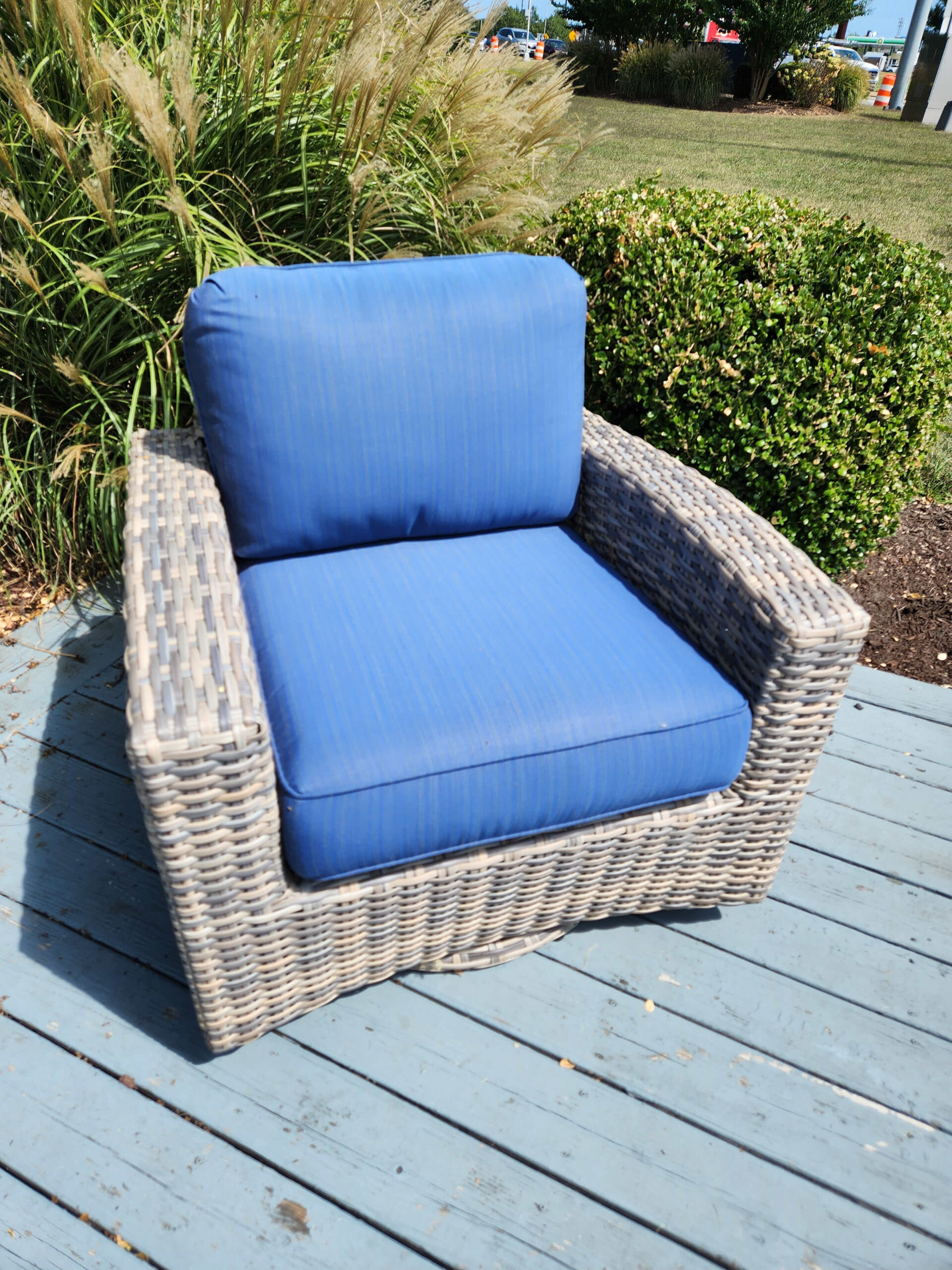 a blue couch sitting on top of a grass covered field