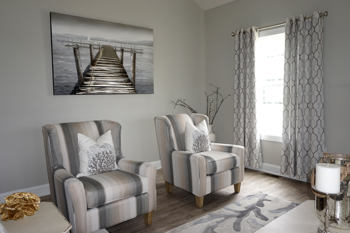 a living room filled with furniture and a painting on the wall