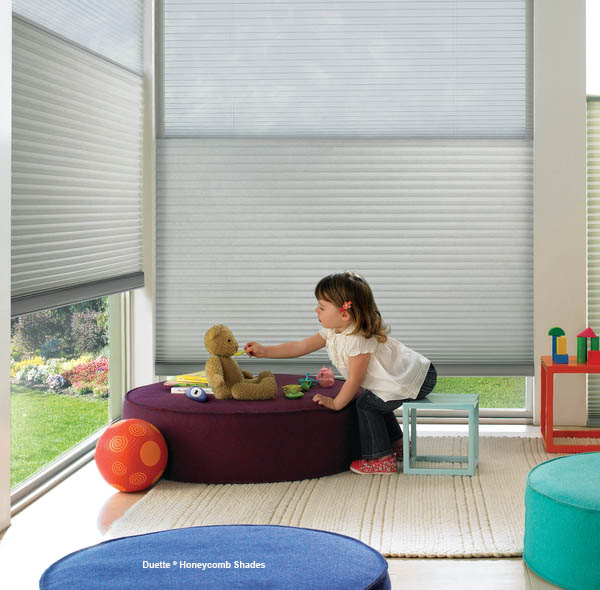 a little girl playing with a teddy bear in a playroom