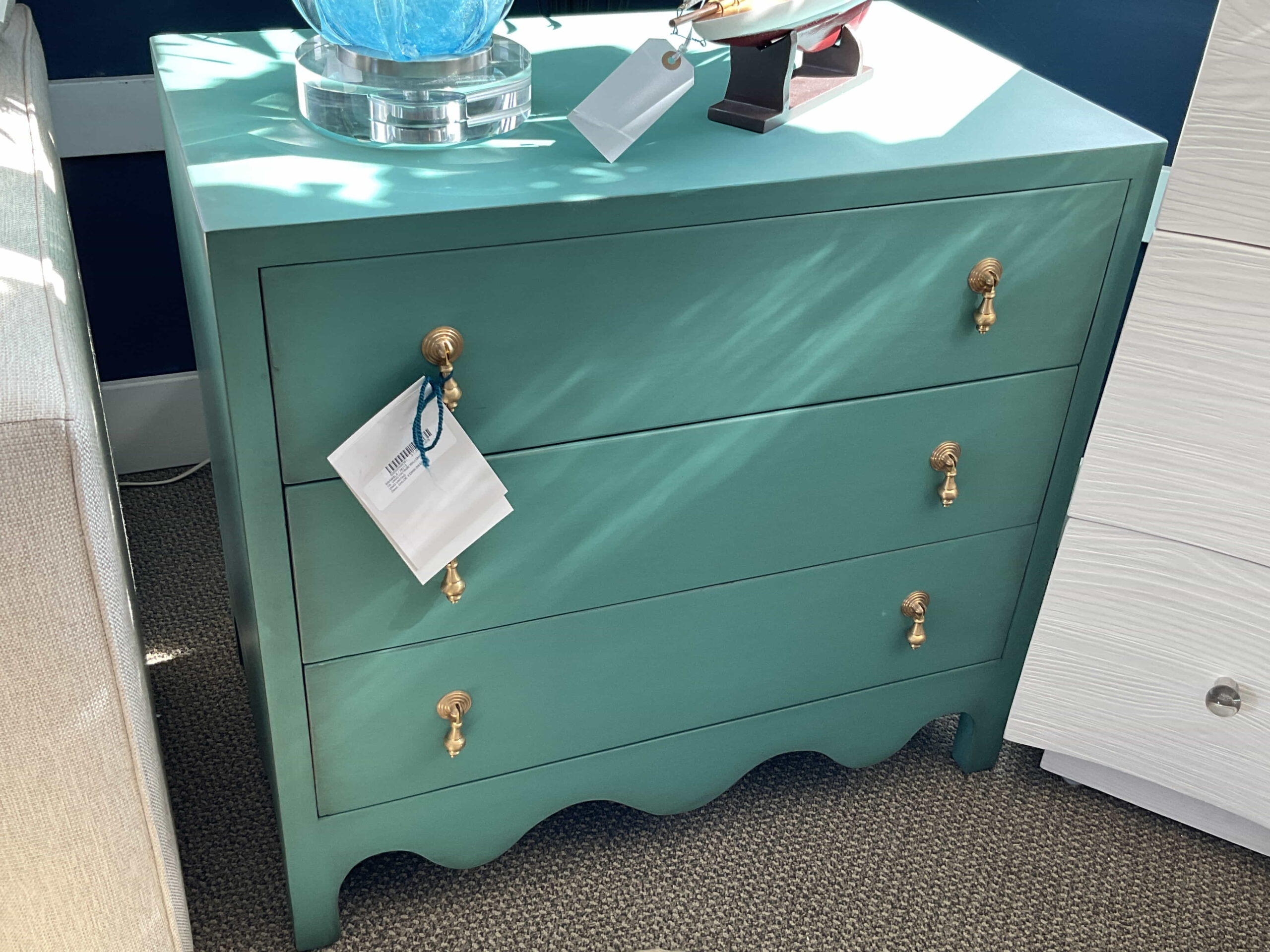 a green dresser with a blue vase on top of it