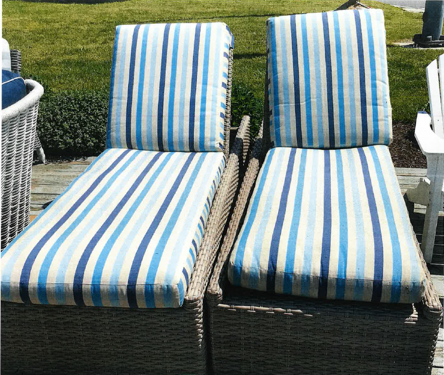 two blue and white striped chairs sitting on a patio