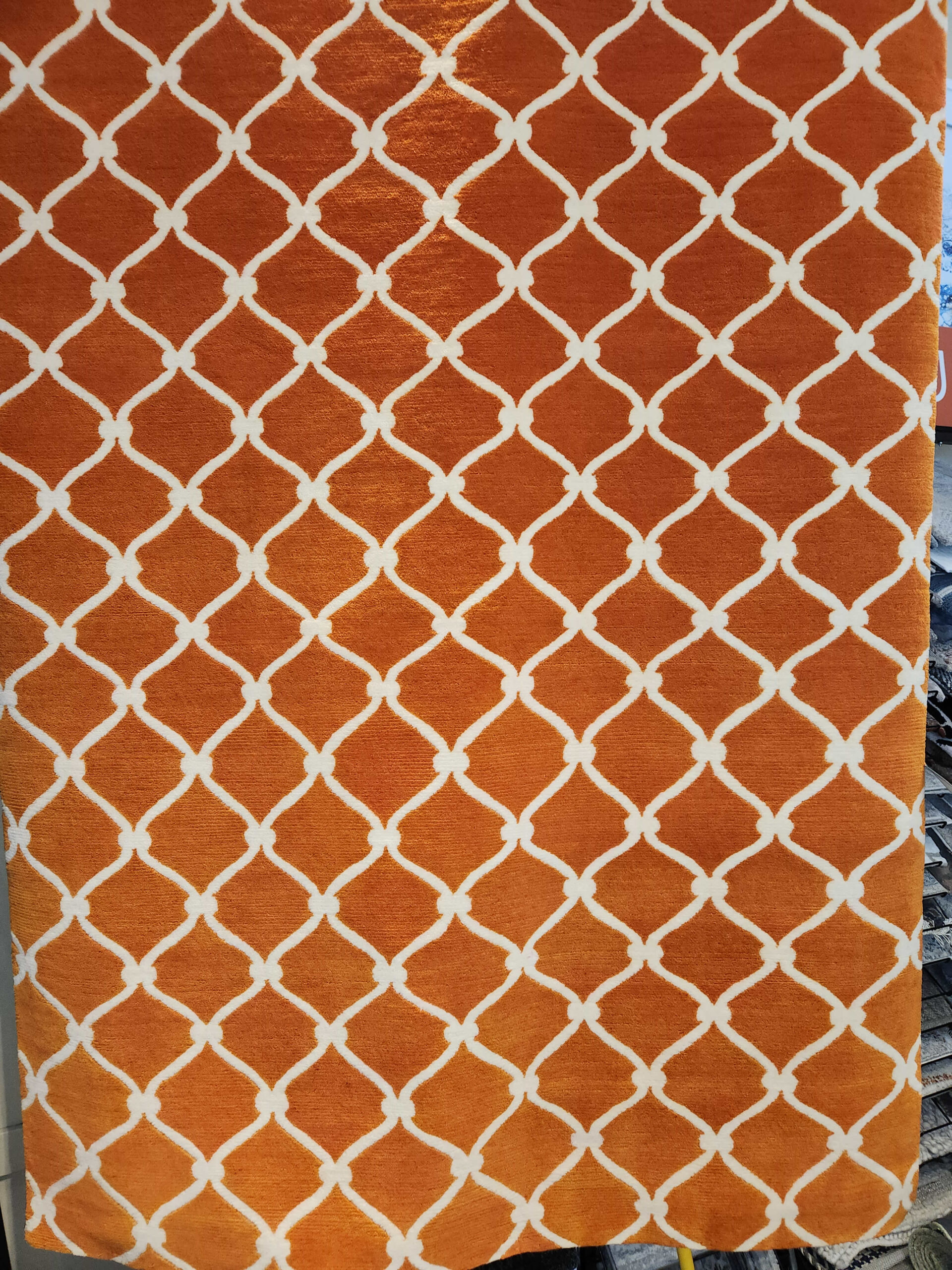 a piece of orange and white fabric with a trellis pattern