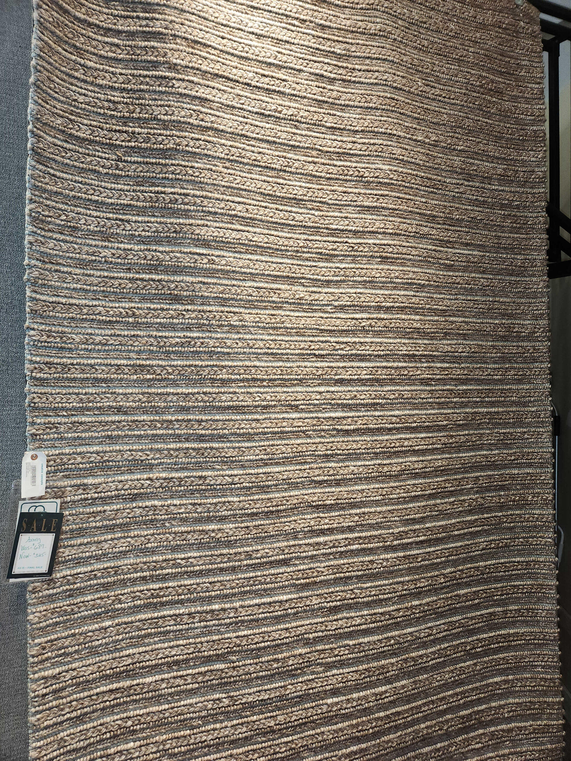 a close up of a carpet with a chair in the background