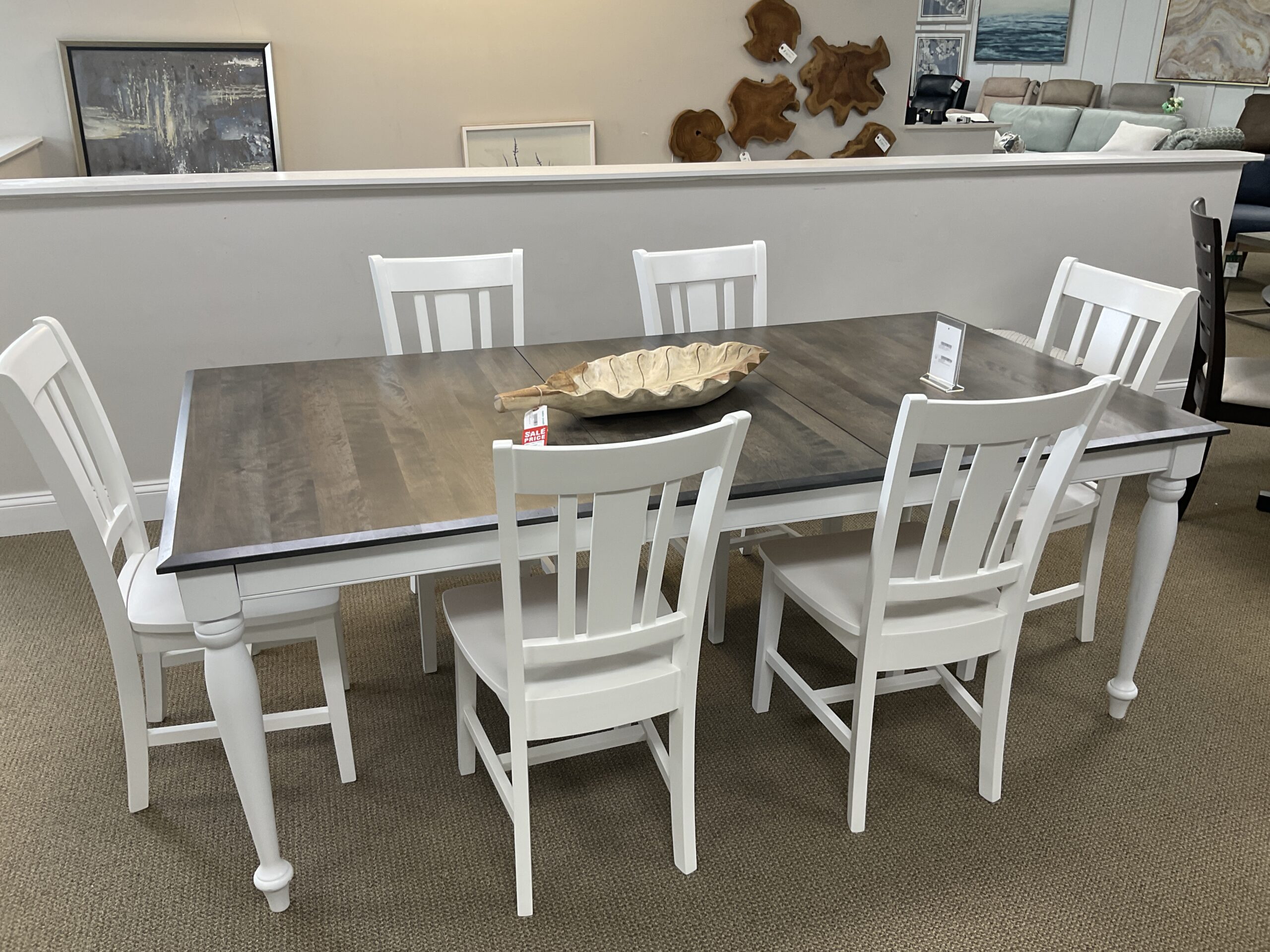 a dining room table with white chairs and a black table